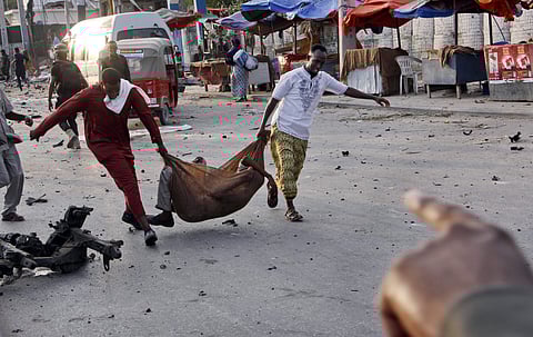 Somalis carry away an injured civilian at the scene of a bomb blast near the Sahafi hotel in the capital Mogadishu | AP
