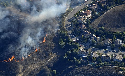 A fast-moving wildfire across Northern California's Butte County burned a hospital, hundreds of homes and left five dead on Friday.  IN PIC: Fires burn toward homes as seen from a helicopter over the Calabasas section of Los Angeles. (Photo: AP)