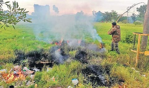 A BBMP marshal puts out a fire on Bellandur lake on Thursday (File | EPS)