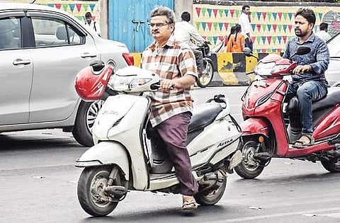 Two-wheeler riders without helmet in Vijayawada on Thursday I P Ravindra Babu
