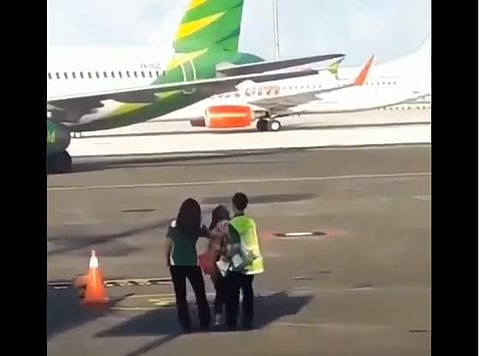 Woman trying to chase down a plane in Bali runway. (Photo | Twitter/@goenrock)