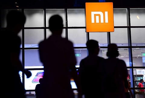 People walk past a Xiaomi store in Shenyang, Liaoning province, China. (File Photo | Reuters)