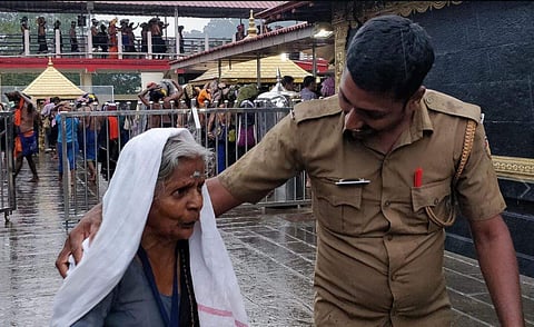 A Kerala cop on duty with a devotee at Sabarimala (Photo | Facebook/Kerala Police)