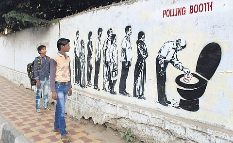 Graffiti displaying a long queue of voters standing in line only to dunk their vote in a toilet pot as drawn on the walls of a school in Hyderabad near Gachibowli | Sathya Keerthi