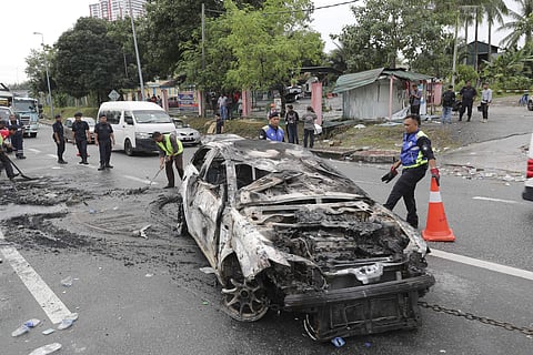 Police remove the wreckage of a burned car after rioting outside Sri Maha Mariamman temple in Subang, Malaysia, Tuesday, Nov. 27, 2018. (Photo | AP)