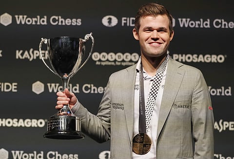Reigning chess world champion, Norway's Magnus Carlsen celebrates with the trophy after retaining the World chess Championship in London. (Photo | AP)
