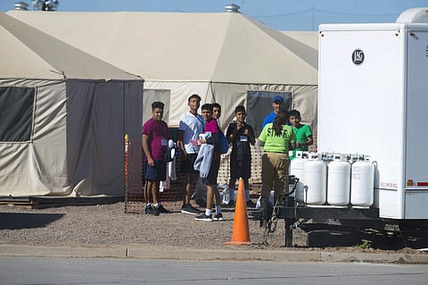 In this Nov. 15, 2018 photo provided by Ivan Pierre Aguirre, migrant teens held inside the Tornillo detention camp look at protestors waving at them outside the fences surrounding the facility in Tornillo, Texas. (Photo | AP)