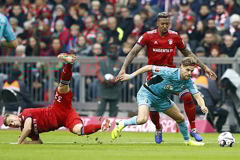 Bayern's Joshua Kimmich (L) and Jerome Boateng (R) challenge Freiburg's Lucas Hoeler during their German Bundesliga match | AP