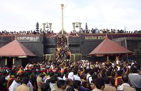 Devotees sit in protest on the sacred Eighteen steps without the mandatory Irumudi kettu which is required to climb the eighteeen steps following rumours that a woman reached the sannidhanam on Tuesday morning. (Photo: BP Deepu / EPS)