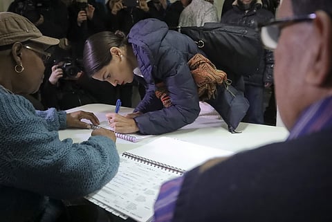 New York Democratic congressional candidate Alexandria Ocasio-Cortez, center, signs a register before voting, Tuesday Nov. 6, 2018, in the Parkchester community in the Bronx, N.Y (Photo | AP)