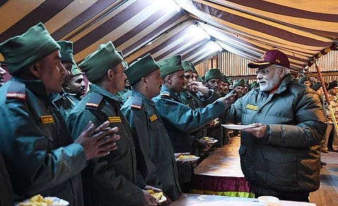 PM sharing sweets with jawans stationed at Harsil village near Indo-China border. (Photo | Twitter/@narendramodi)