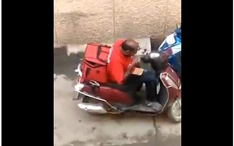 Zomato delivery man eating from tne parcels. (Photo: Screengrab from twitter video.)
