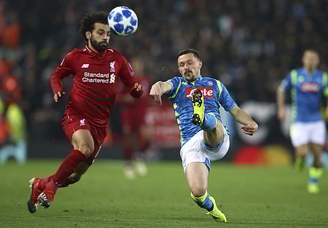 Liverpool forward Mohamed Salah, left, and Napoli defender Mario Rui challenge for the ball during the Champions League Group C soccer match between Liverpool and Napoli at Anfield stadium in Liverpool. (Photo | AP)