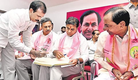 TRS leader KT Rama Rao signs in a register after being elected party working president. (Top) Party workers in Khammam celebrate KT Rama Rao’s elevation | Express