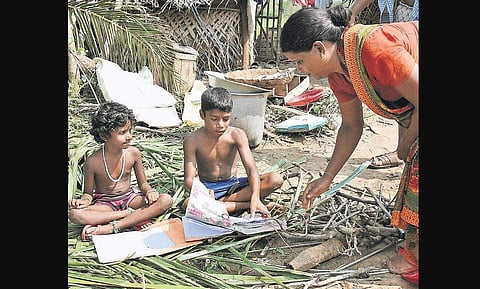 With all their stationery items soaked wet by Cyclone Gaja, children dry their books out in the sun in Nagapattinam. (Photo | MK Ashok Kumar/ EPS)