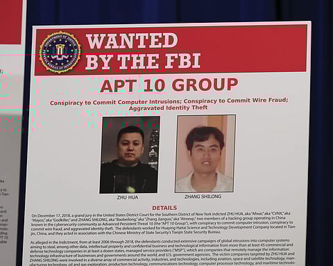 A poster displayed during a news conference at the Department of Justice in Washington shows two Chinese citizens suspected to be with the group APT 10 carrying out an extensive hacking campaign to steal data from U.S. companies. (File |AP)