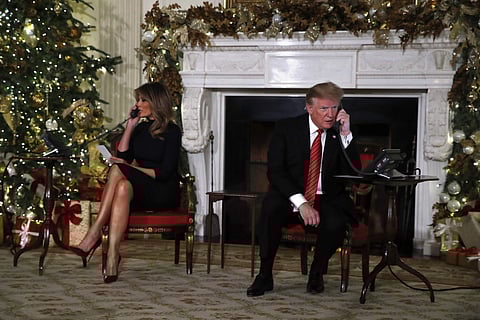 President Donald Trump and first lady Melania Trump each speak on the phone sharing updates to track Santa's movements from the North American Aerospace Defense Command (NORAD) Santa Tracker on Christmas Eve. (Photo | AP)