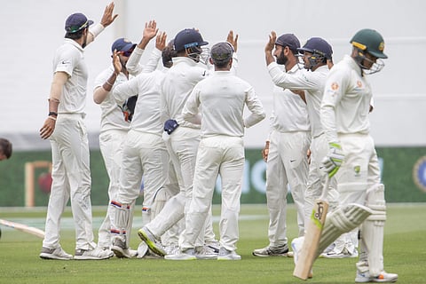 Indian team members celebrate the wickets of Australia's Usman Khawaja as he departs during play on day 3 of the 3rd Test