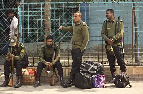 Bangladeshi police personnel wait to accompany polling officials at a distribution center on the eve of the general elections in Dhaka (Photo | AP)