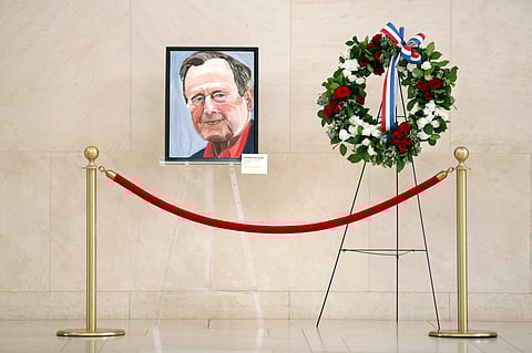 A painted portrait of the late 41st President George H.W. Bush -- painted by his son, Pres. George W. Bush -- and a memorial wreath grace the atrium area of his son's George W. Bush Presidential Library and Museum in University Park, Texas, Sunday, Dec. 2