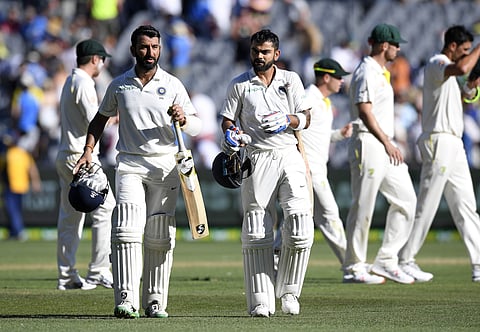 India's India's Cheteshwar Pujara, left, and Virat Kohli leave the field after play on day one of the third cricket test between India and Australia in Melbourne. (Photo | AP)