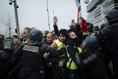 French riot police officers hold back demonstrators wearing yellow vests as they demonstrate in front of the french public television network (France Televisions) in Paris, Saturday, Dec. 29, 2018. (Photo | AP)
