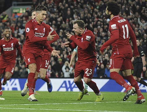 Liverpool's Roberto Firmino, left, celebrates with teammates after he scores his sides 5th goal and his 3rd from the penalty spot during the English Premier League soccer match between Liverpool and Arsenal at Anfield in Liverpool. (Photo | AP)