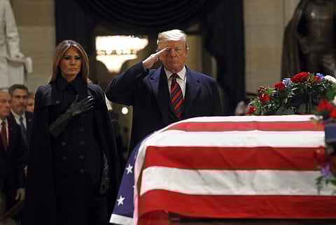 President Donald Trump salutes alongside first lady Melania Trump in front of the flag-draped casket of former President George H.W. Bush in the Capitol Rotunda in Washington, Monday, Dec. 3, 2018. (Photo | AP)