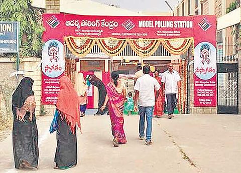 People walk into the model polling station decked up with flowers in Nizamabad on Friday | Express photo