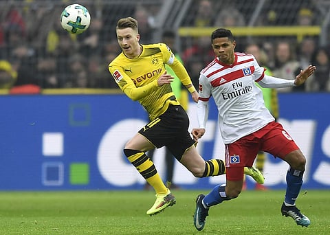Dortmund's Marco Reus, left, and Hamburg's Douglas Santos challenge for the ball during the German Bundesliga soccer match between Borussia Dortmund and Hamburger SV in Dortmund, Germany, Saturday, Feb. 10, 2018.