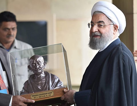 Iranian President Hassan Rouhani being presented with a bust of Mahatma Gandhi after they paid homage at Rajghat in New Delhi on Saturday. | PTI