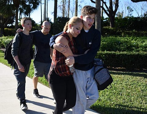 Students react following a shooting at Marjory Stoneman Douglas High School in Parkland, Florida. | AFP