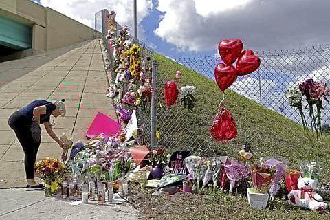 3 1 2 3 4 Ann Newman, of Deerfield Beach, Fla., a retired Broward County teacher, places flowers at a makeshift memorial at Marjory Stoneman Douglas High School in Parkland. | AP