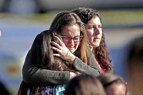Students released from a lockdown embrace following following a shooting at Marjory Stoneman Douglas High School in Parkland, Florida (AP)