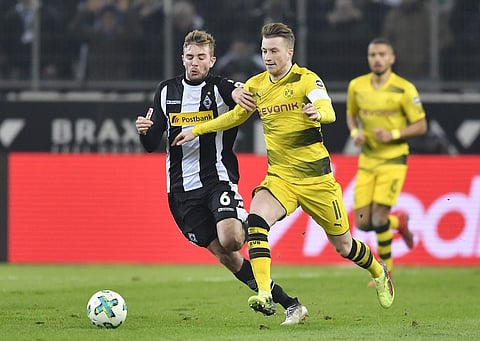 Borussia Dortmund's Marco Reus, right, and Borussia Moenchengladbach's Christoph Kramer challenge for the ball during the German Bundesliga soccer match. | AP