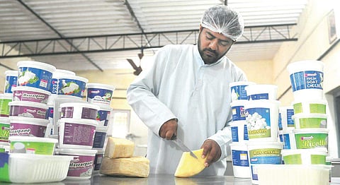Father Michael slicing cheese in his kitchen in T C Palya  Nagesh Polali