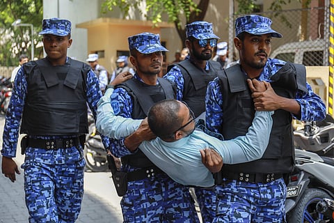 Maldivian police remove one among the opposition members who tried to enter Parliament that remains closed following the state of emergency in Male, Maldives. (AP Photo)