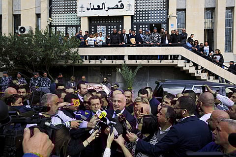 Lebanese talk show host Marcel Ghanem, center, speaks to journalists in front of the courthouse compound, in Beirut's southeastern suburb of Baabda, Lebanon. | AP