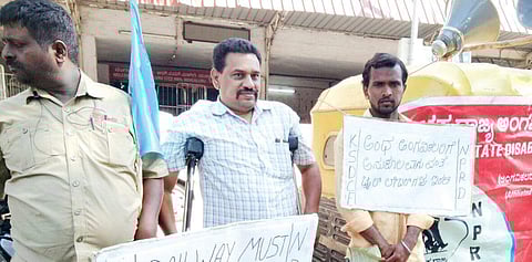 Members of Karnataka State Disabled and Caregivers Federation (KSDCF) stage a protest in front of the City Railway Station on Tuesday.