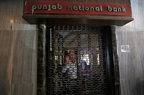 CBI official looks out from a closed door of a Punjab National Bank branch in Mumbai, India. (Reuters)