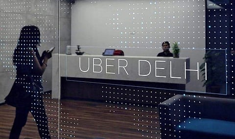 An employee walks inside the office of ride-hailing service Uber in Gurugram. (Photo | Reuters)