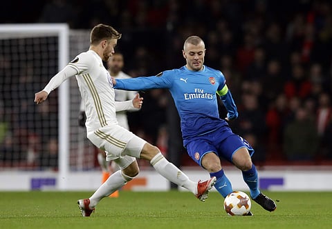 Arsenal's Jack Wilshere, right, battles for the ball with Ostersunds' Dennis Widgren during the Europa League Round of 32, second leg match between Arsenal and Ostersunds FK at the Emirates Stadium in London. (AP)