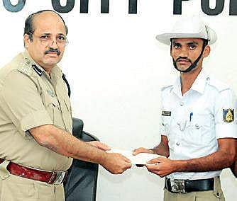 Police Commissioner T R Suresh  presents cash award to Revanasiddappa