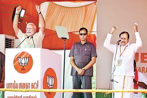 Prime Minister Narendra Modi addressing a public meeting in Puducherry on Sunday, as  BJP national general secretary H Raja translates his speech | G PATTABIRAMAN