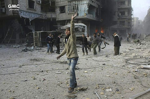 Syrian citizens carry a victim during airstrikes. | AP