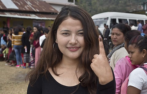 Khasi tribal girl Indari Thabah, 20, who voted for the first time shows her ink mark outside a polling station during the Meghalaya state assembly election in Nongpoh. | AP