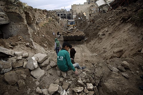 A bulldozer removes rubble next to the heavily damaged Grand Umayyad Mosque in the Old City of Aleppo, Syria. | AP