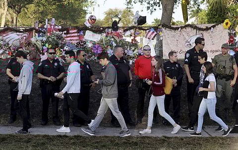 Students are greeted by law enforcement as they head back to school at Marjory Stoneman Douglas High School | AP