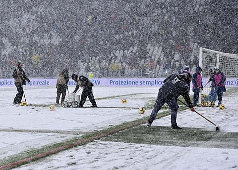 Workers shovel snow from the pitch of the Allianz Stadium in Turin, Italy. | AP