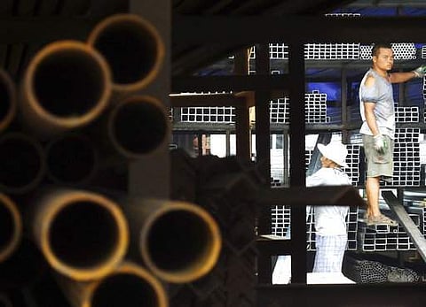 FILE - In this Monday, Aug. 1, 2016 file photo, laborers work at a steel market in Yichang in central China's Hubei province. | AP